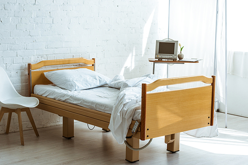 empty bed and medical equipment in hospital ward