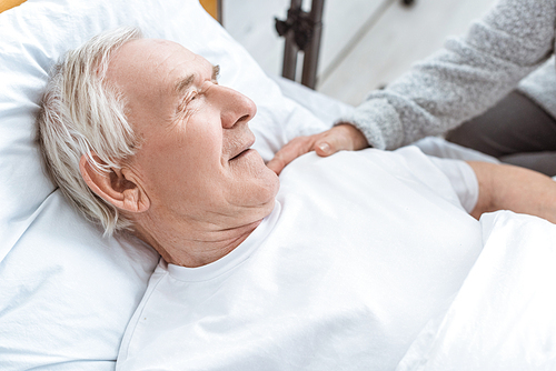 partial view of senior woman with ill husbend in clinic