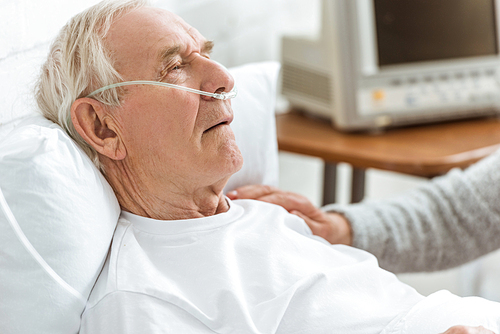 cropped view of senior woman and ill senior man in hospital