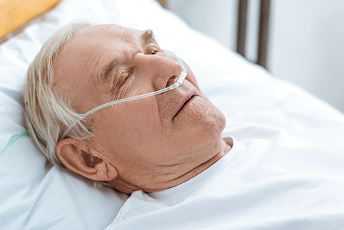 senior unconscious patient with nasal cannula in hospital