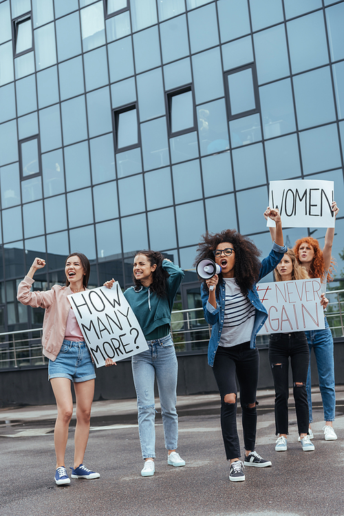 african american girl gesturing while holding megaphone and screaming near girls on meeting