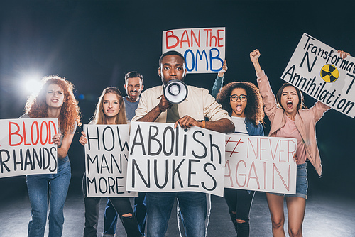 emotional multicultural men and women holding placards with lettering on black