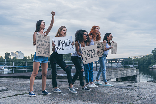 emotional multicultural girls holding placards and screaming outside