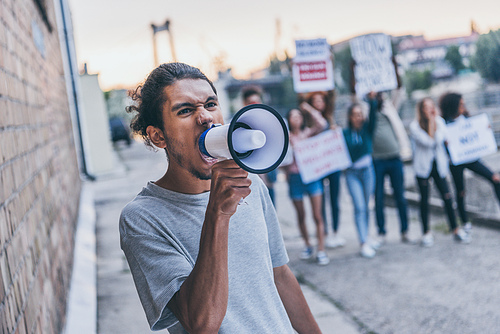 selective focus of african american man screaming in megaphone