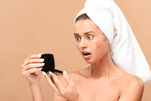 shocked girl in towel with acne on face looking at mirror isolated on beige