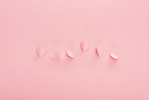 top view of pink paper hearts on pink background