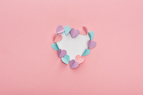 top view of colorful paper hearts as frame on pink background