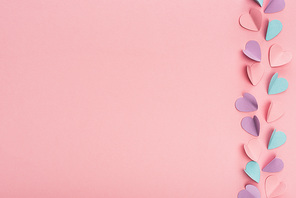 top view of colorful paper hearts on pink background