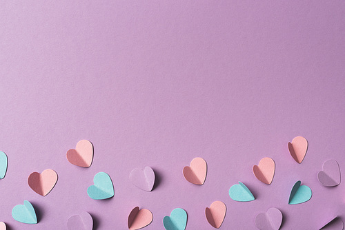 top view of colorful paper hearts on violet background