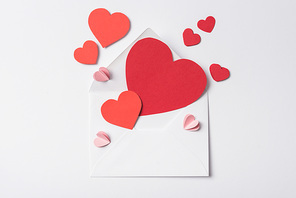 top view of red hearts and envelope on white background