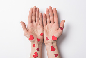 cropped view of woman with red hearts on hands on white background