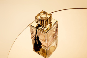 High angle view of perfume bottle on golden round mirror surface
