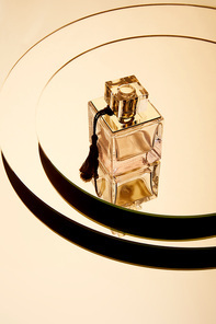 Luxury perfume bottle on round mirror surface with reflection