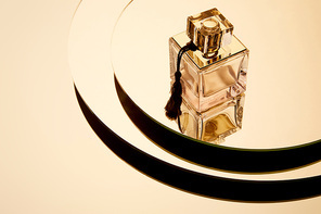 High angle view of luxury perfume bottle on round mirror surface with reflection