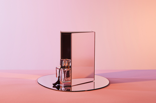 perfume bottle on round mirror with cube on pink background