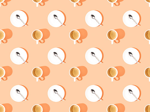 top view of cups of fresh coffee and spoons on plates on orange, seamless background pattern
