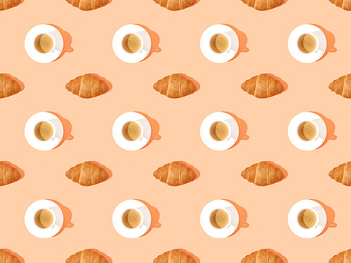top view of fresh croissants on plates and coffee on orange, seamless background pattern