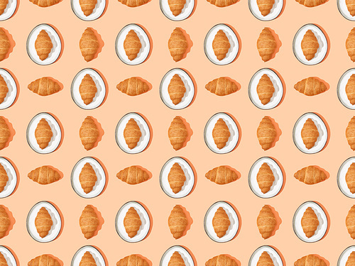 top view of fresh croissants on plates on orange, seamless background pattern