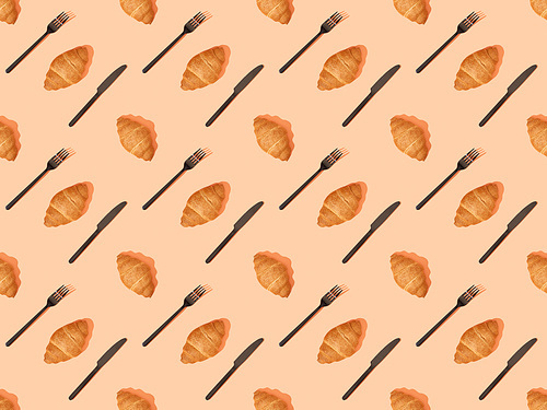 top view of cutlery and fresh croissants on orange, seamless background pattern