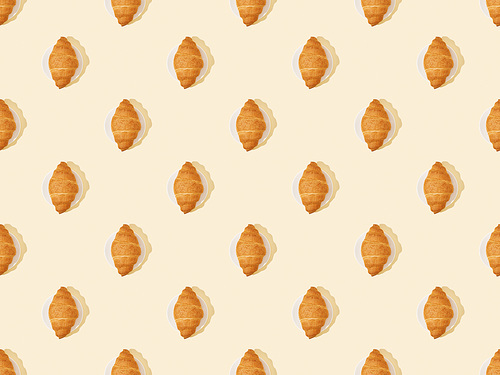 top view of fresh croissants on beige, seamless background pattern