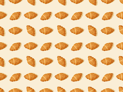 top view of fresh croissants on beige, seamless background pattern