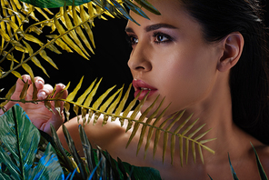 Portrait of beautiful woman with leaves isolated on black