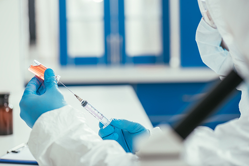 selective focus of biochemist taking medicine from glass container with syringe