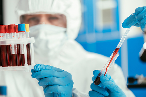 selective focus of biochemists holding test tubes with blood samples