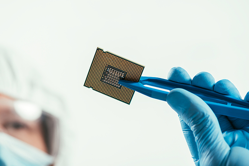 cropped view of engineer holding computer microchip with tweezers
