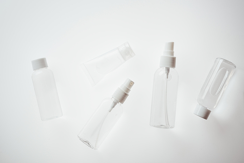 top view of white bottles with liquids ob white background