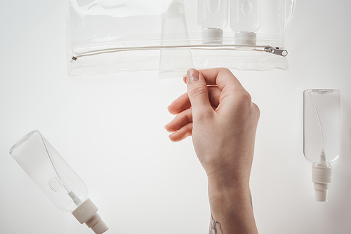 cropped view of woman holding tube with liquid on white background