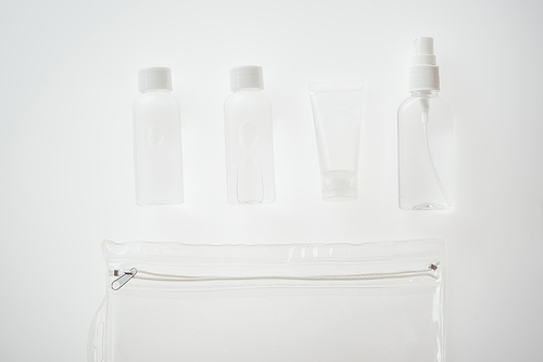 top view of bottles and tube with liquids on white background