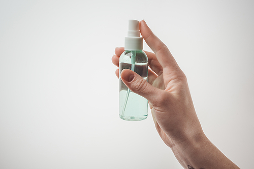 cropped view of woman holding bottle with liquid on white background