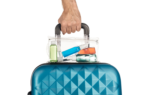 cropped view of man holding travel bag with cosmetic bag with colorful bottles with liquids on white background