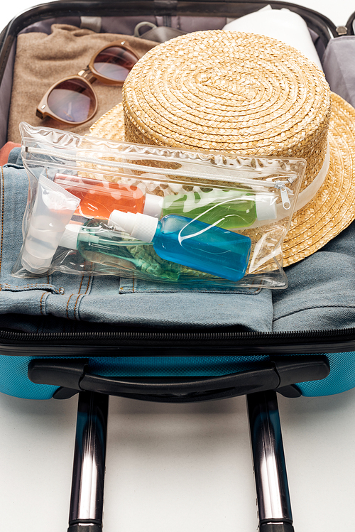 travel bag with towel, cosmetic bag with bottles, clothes, sunglasses and hat