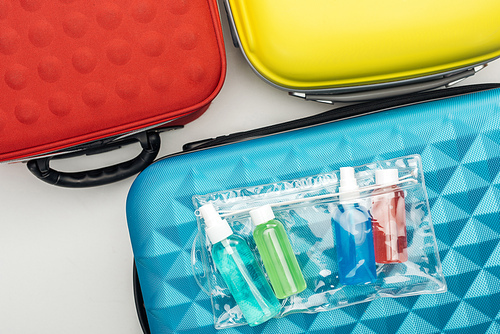 top view of cosmetic bag and bottles with liquids on travel bag