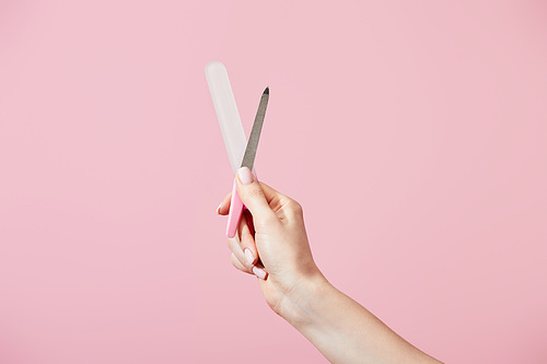 Cropped view of female hand with nail files isolated on pink