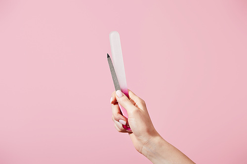 Partial view of female hand with nail files isolated on pink