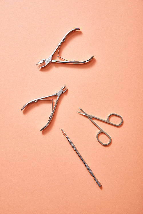 Top view of manicure instruments on coral background