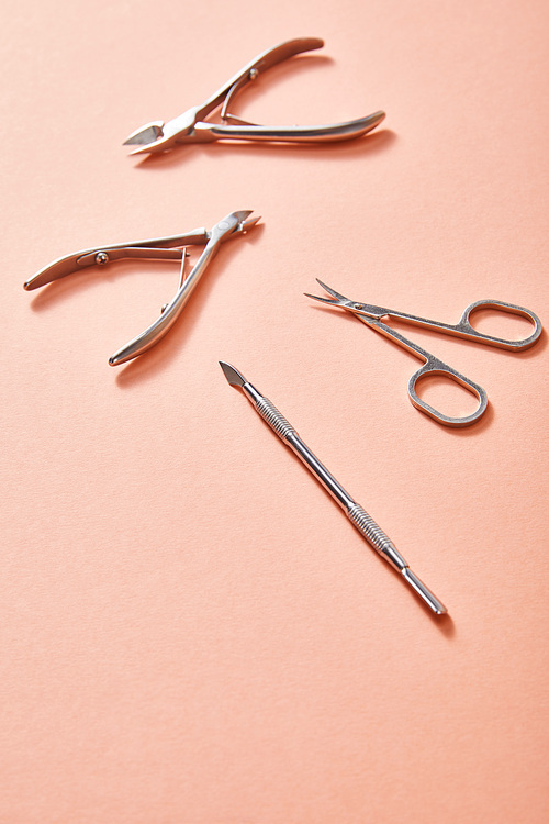 High angle view of manicure instruments on coral background