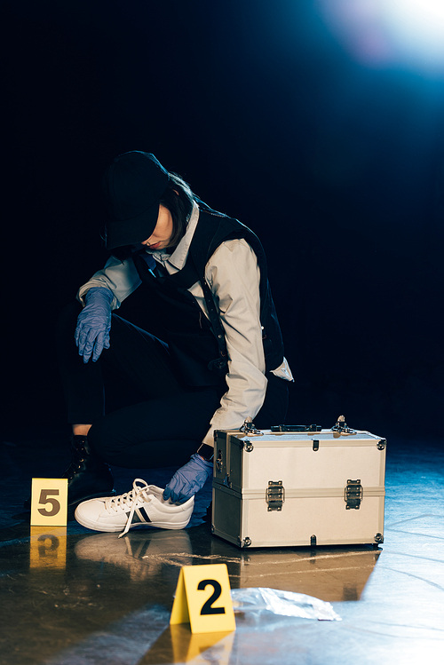 investigator in uniform holding shoe at crime scene