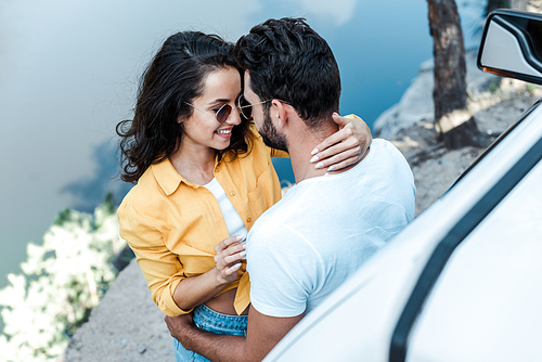 overhead view of girl hugging bearded man near automobile