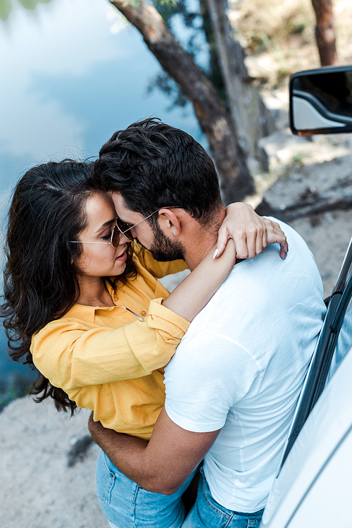 overhead view of girl hugging boyfriend near automobile