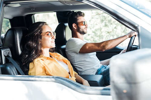 selective focus of attractive girl near man driving car