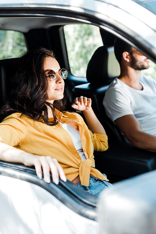 selective focus of attractive girl near driver in car