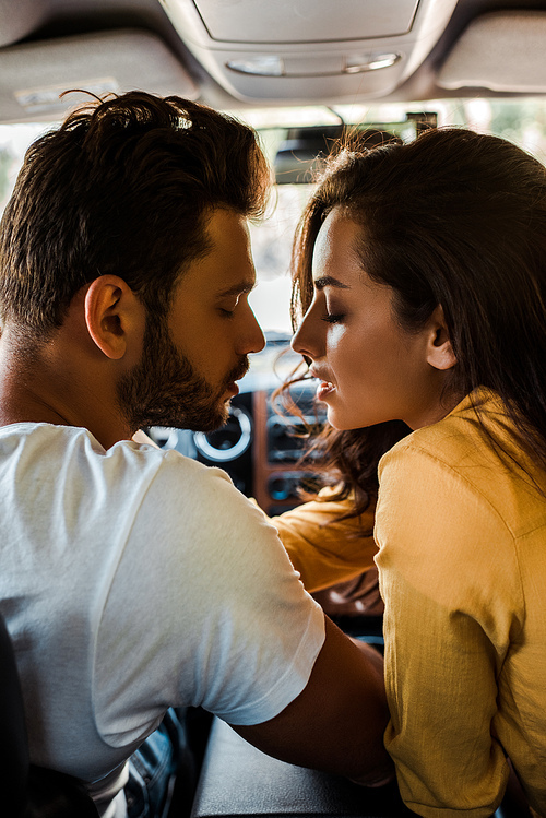 side view of handsome man and attractive woman with closed eyes in car