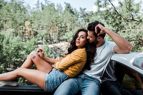 bearded man sitting and looking at girl in woods