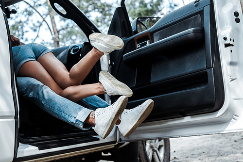 cropped view of young man and woman making out in modern car