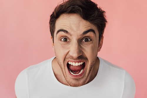 front view of angry man screaming and  isolated on pink