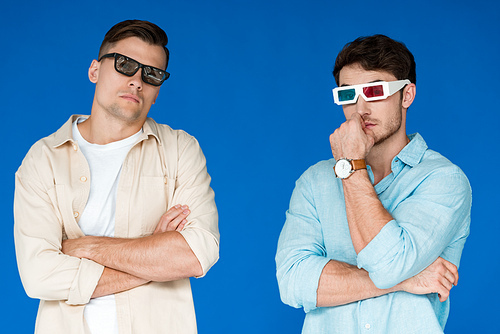 two serious friends in 3d glasses isolated on blue